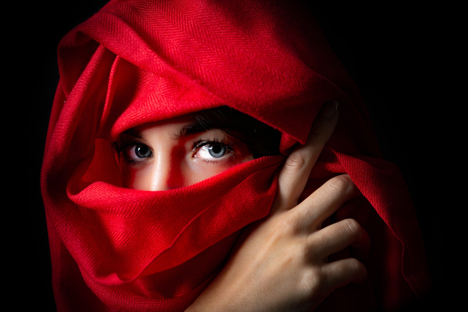 Woman draped in Laal's red plain 100% cashmere pashmina shawl, embodying the pure elegance and warmth of Laal's Pashmina collection