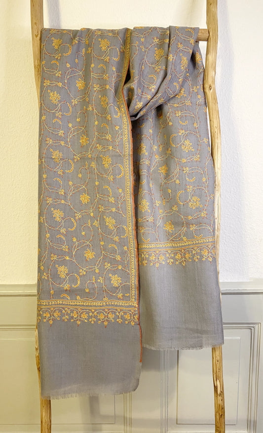 Luxuriously crafted and exquisitely detailed, this jaalidar pashmina stole stands as a statement of elegance and sophistication. At 70x200 cm and a mere 120 grams, it epitomizes luxury in every fiber. The stole, woven from the rare Yangir wool of the Himalayan Ibex, promises unparalleled softness. Its soft grey canvas, enriched with intricate yellow embroidery, reflects regal finesse and is a prized addition to any luxury collection.