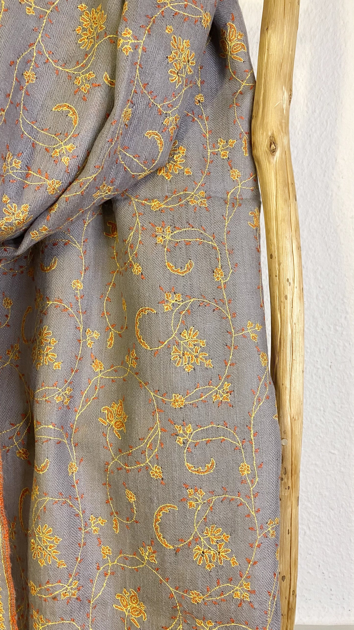 Luxuriously crafted and exquisitely detailed, this jaalidar pashmina stole stands as a statement of elegance and sophistication. At 70x200 cm and a mere 120 grams, it epitomizes luxury in every fiber. The stole, woven from the rare Yangir wool of the Himalayan Ibex, promises unparalleled softness. Its soft grey canvas, enriched with intricate yellow embroidery, reflects regal finesse and is a prized addition to any luxury collection.