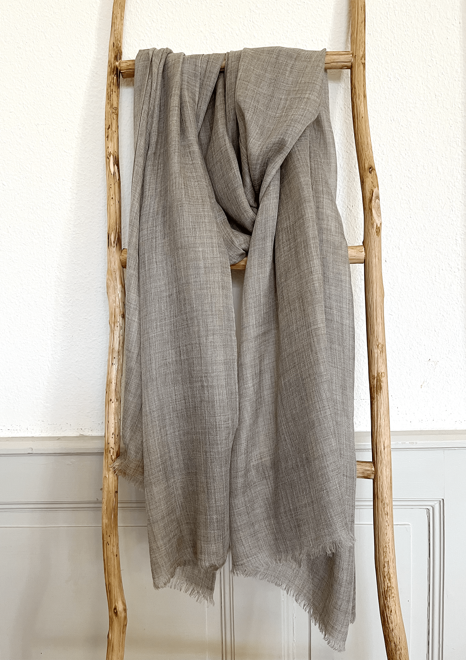 Laal's Pure Baby Pashmina Shawl, embodying luxury with its ultra-soft, lightweight, and breathable baby cashmere. Crafted from first-combed baby goat fibers, it features a delicate weave in five natural cashmere colors. Handspun and woven in Kathmandu, this oversized, unisex shawl with eyelash fringes is versatile for autumn, winter, and spring. Warm, comfortable, and itch-free, it's an ideal gift for any occasion.