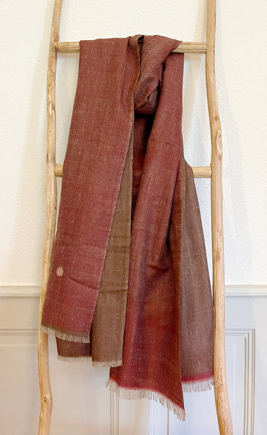 Laal's Signature Reversible Pashmina Stole, a fusion of historic elegance and luxury from the valleys of Kashmir. Crafted from 100% pure cashmere since the 1860s, these stoles are light yet insulating, perfect for various settings from city chic to casual gatherings. Available in six color combinations, each piece reflects the beauty of the Himalayas. Meticulously woven by artisans from Srinagar